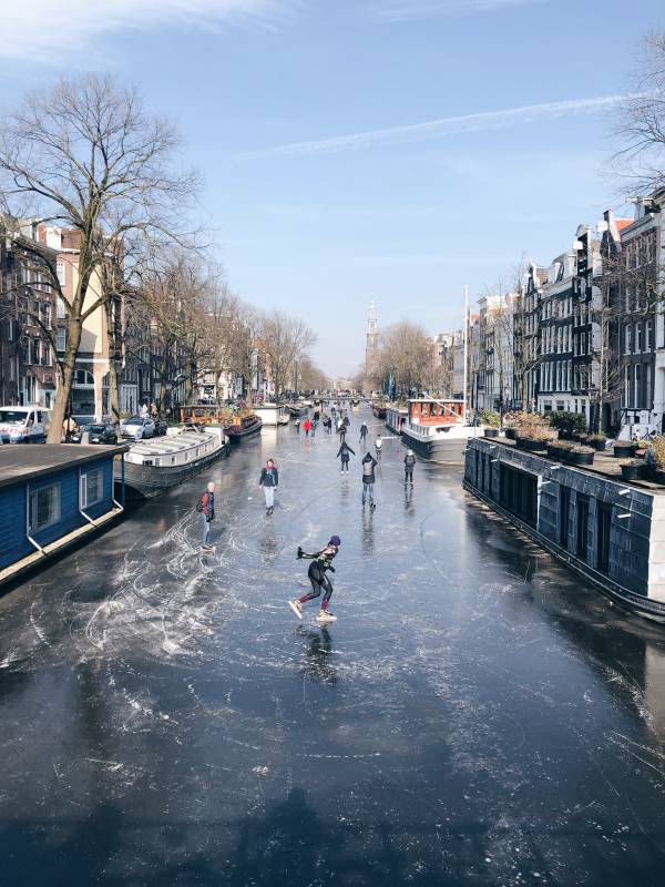 Människor åker skridskor på kanalerna i Amsterdam