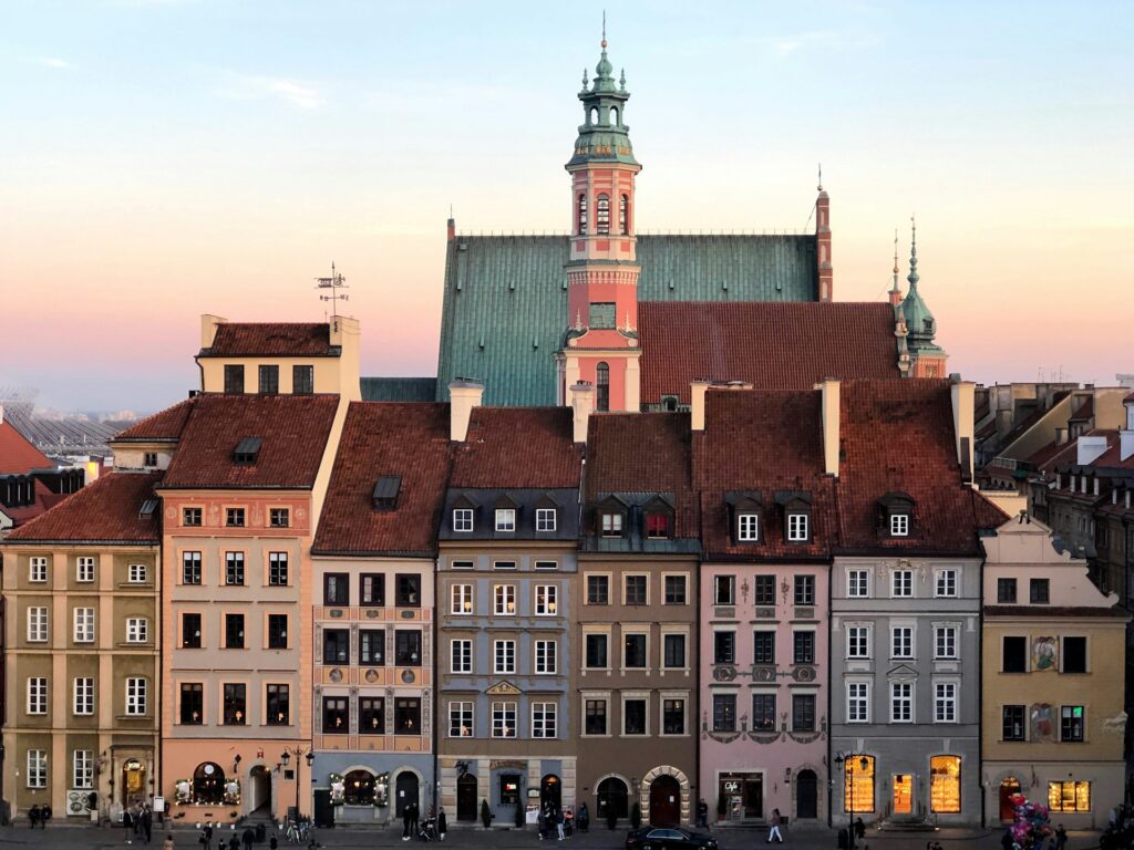 Blick auf Menschen, die in der Nähe und vor einem bunten Gebäude in Warszawa, Polen, spazieren gehen