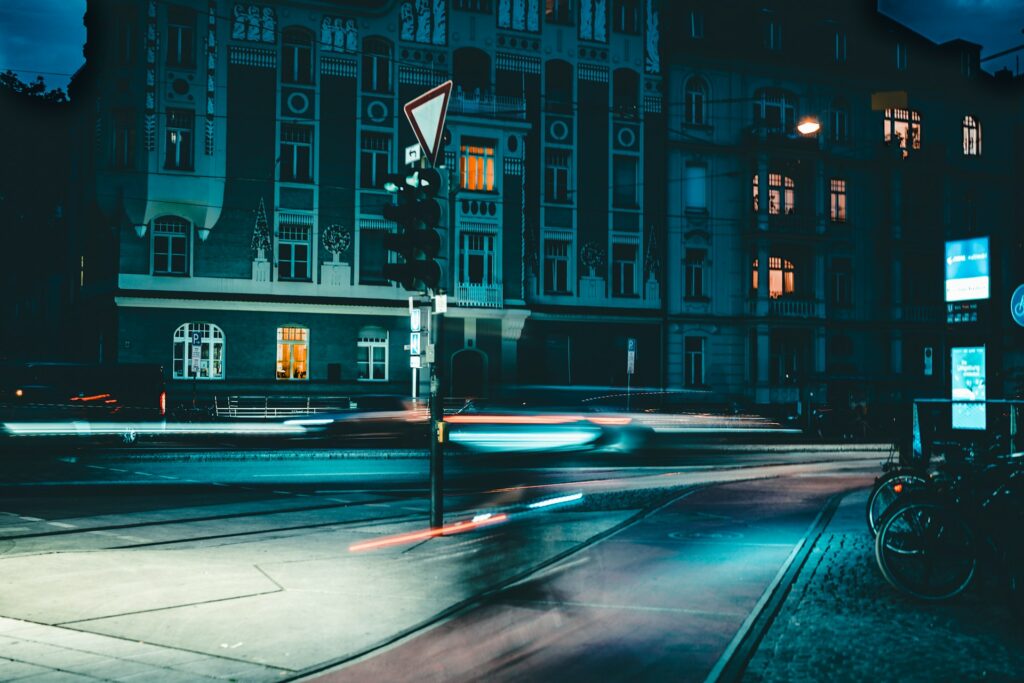 Blick auf eine Straße in München bei Nacht mit verschwommenen Lichtern.