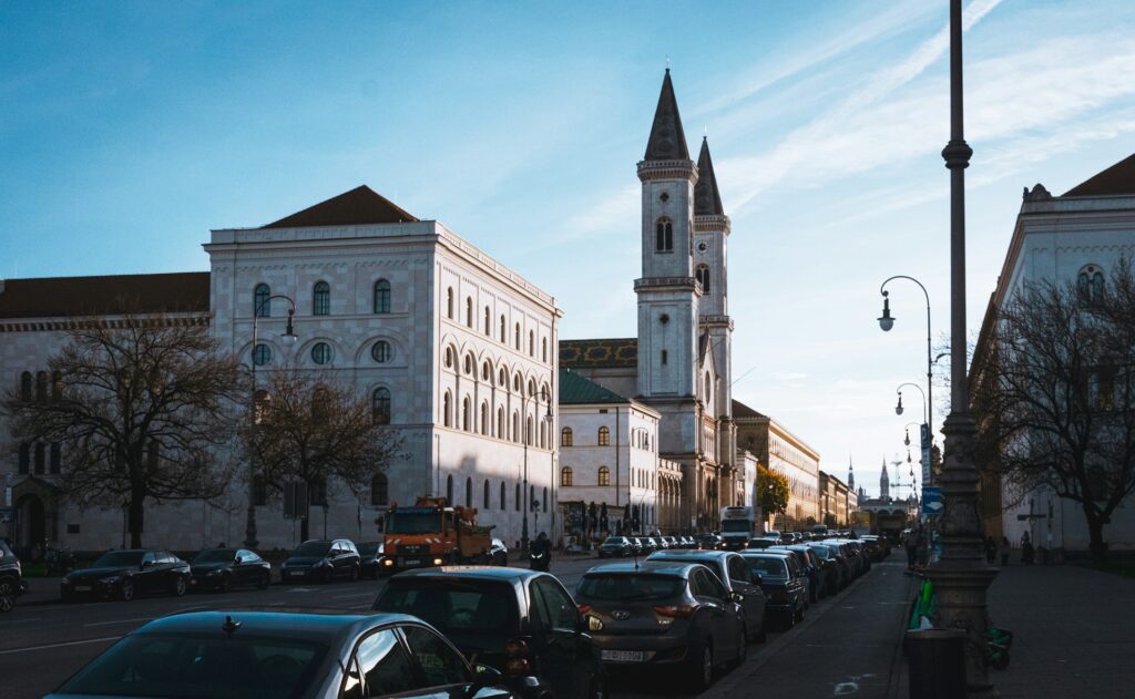 Eine Straße in München mit Autos und Gebäuden entlang der Straße.