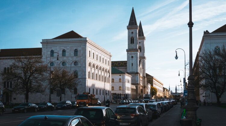 Eine Straße in München mit Autos und Gebäuden entlang der Straße.