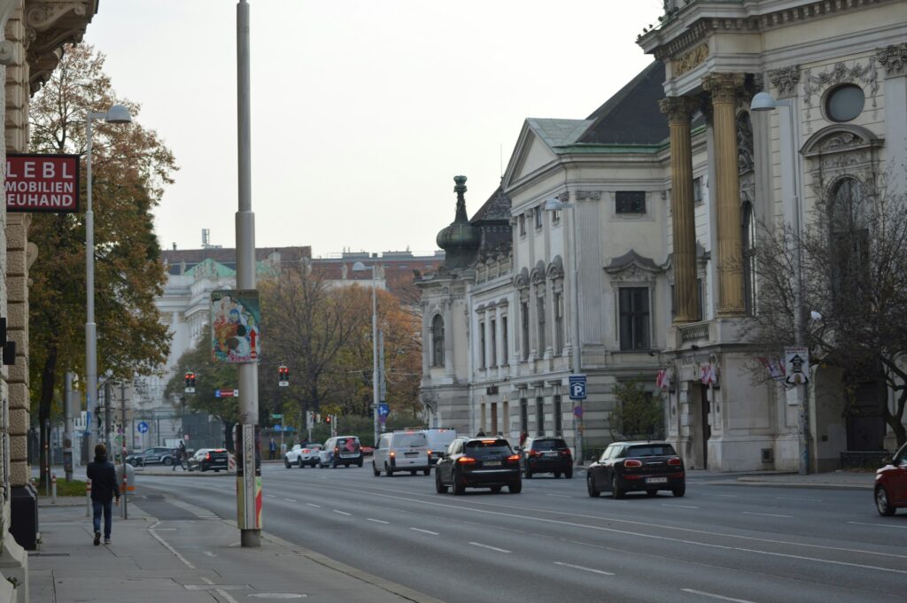 Eine belebte Straße neben hohen Gebäuden in Wien