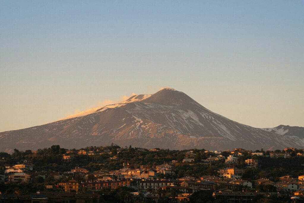 Blick auf den Vulkan Ätna mit Schneefeldern und die Umgebung bei Sonnenuntergang, Sizilien, Italien.