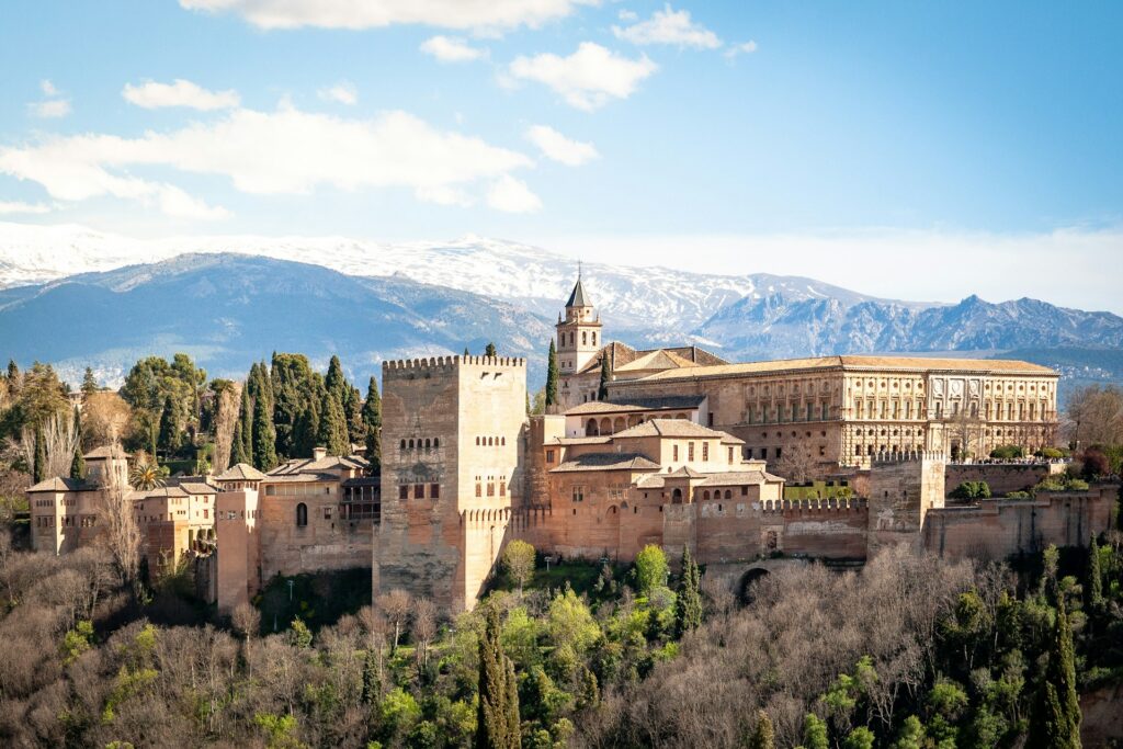 Blick auf die Alhambra in Granada vor den schneebedeckten Bergen der Sierra Nevada, Andalusien, Spanien.