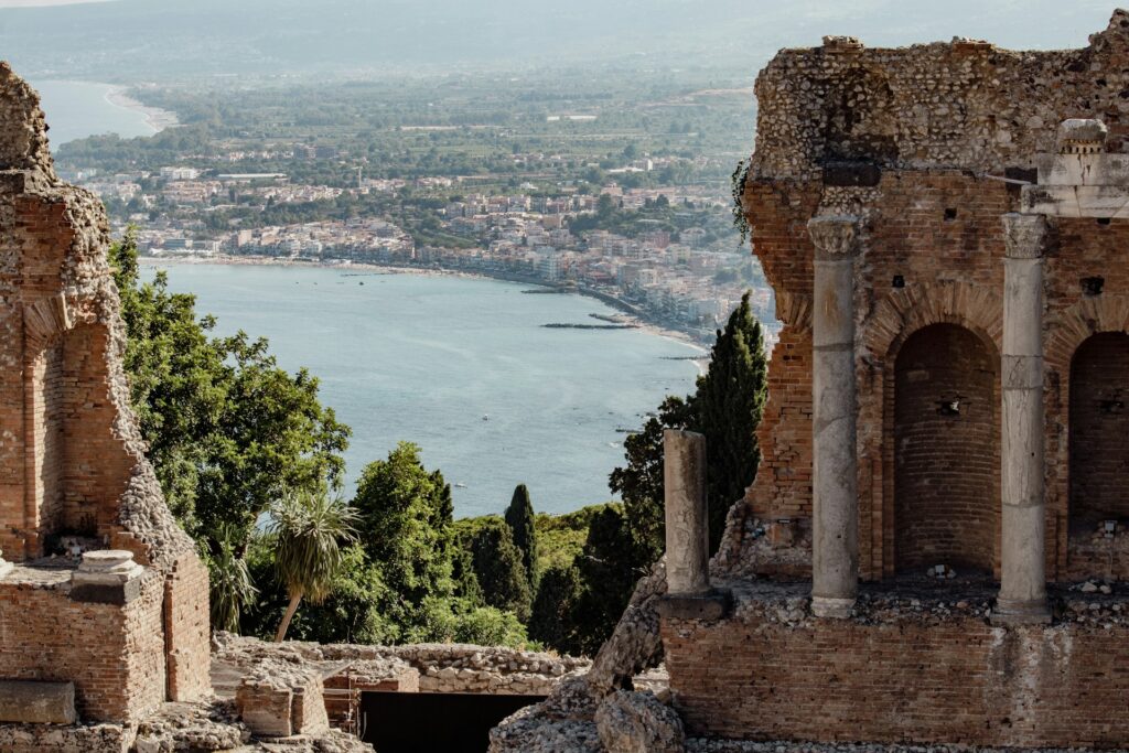 Antikes Theater von Taormina mit Ausblick auf das Mittelmeer und die Küstenlandschaft, Sizilien.