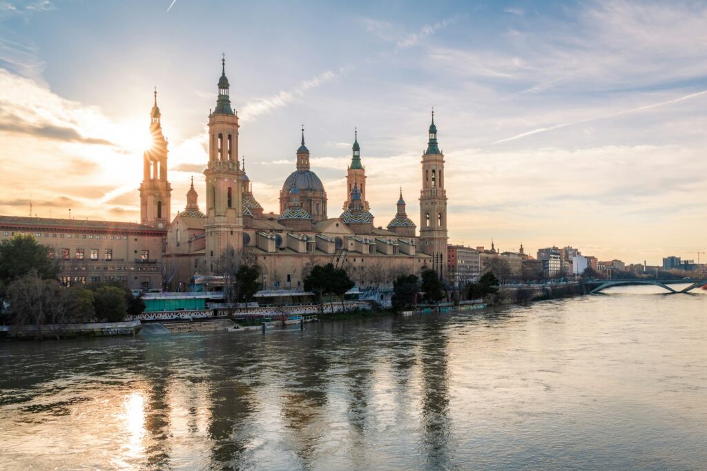Basilika Nuestra Señora del Pilar in Zaragoza, Aragon, Spanien, im Sonnenuntergang und Spiegelung im Ebro-Fluss.