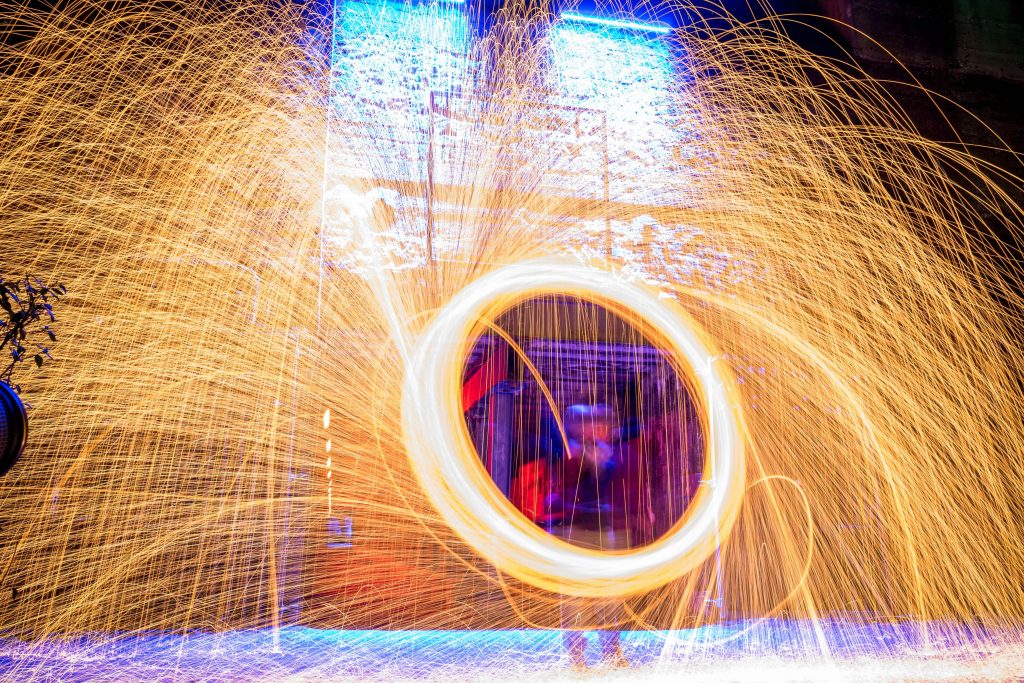 Spektakuläre Lichtinstallation mit Funkenkranz und Lichtspuren bei Nacht im Landschaftspark Duisburg-Nord.