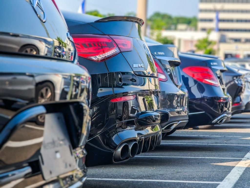 Mehrere Fahrzeuge stehen in einer Reihe auf einem Parkplatz im Freien.