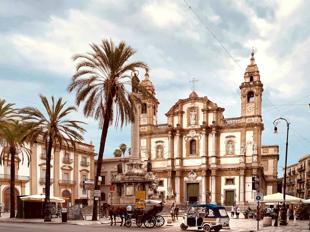 Barocker Platz in Palermo mit der Kirche San Domenico, Palmen und einer Pferdekutsche.