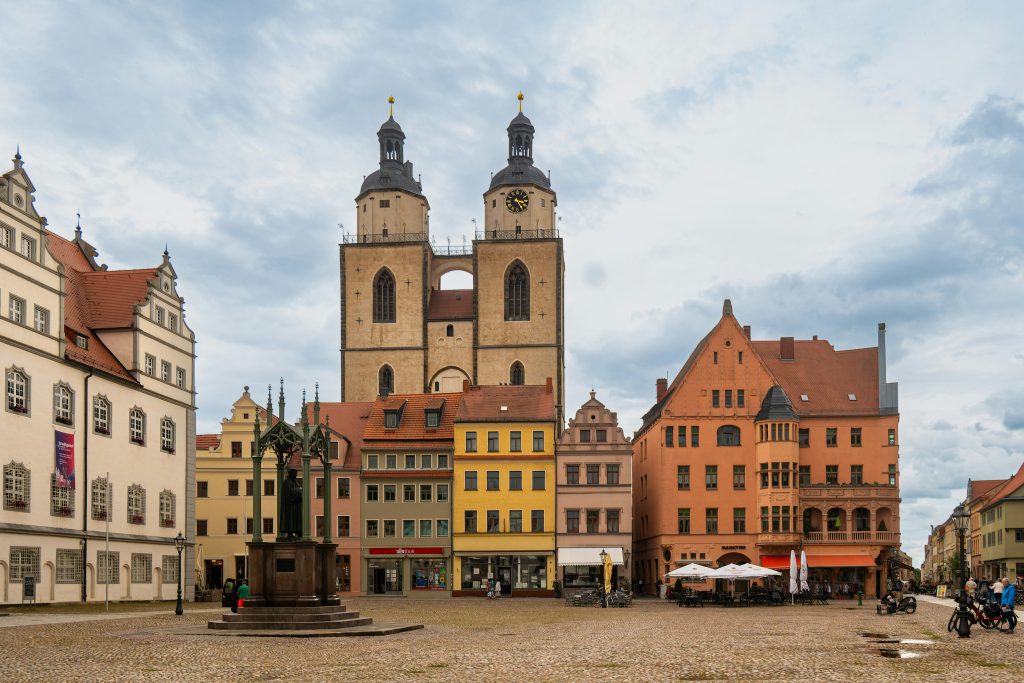 Marktplatz der Lutherstadt Wittenberg mit der Stadtkirche, bunten Bürgerhäusern und dem Lutherdenkmal.