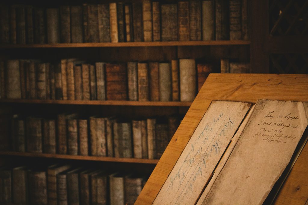 Alte Holzbücherregale mit historischen Büchern in einem mittelalterlichen Gebäude.